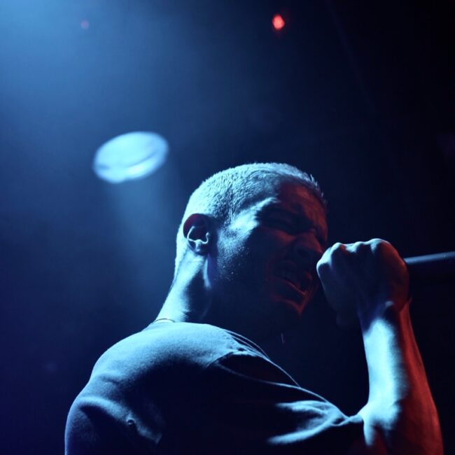 man holding microphone performing on stage