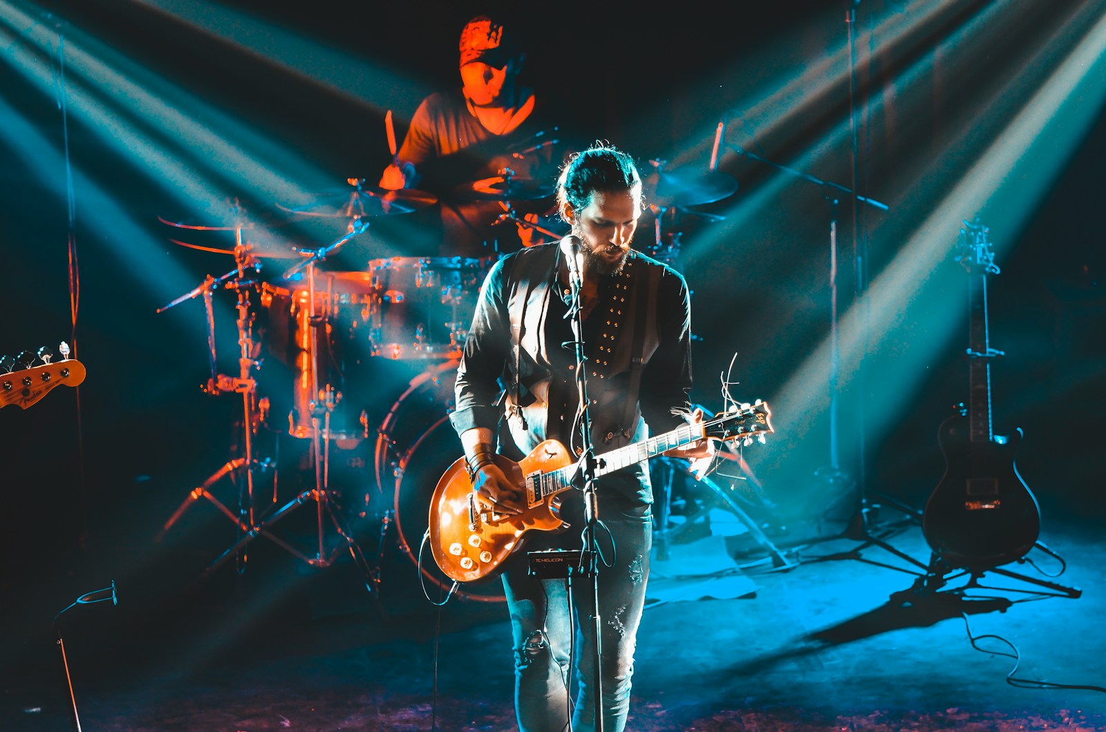 man in black leather jacket playing guitar